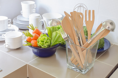 36720779 - utensils in glass bottle on kitchen's counter at home
